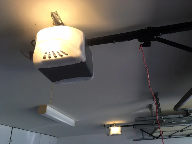 Older garage door opener mounted on a garage ceiling