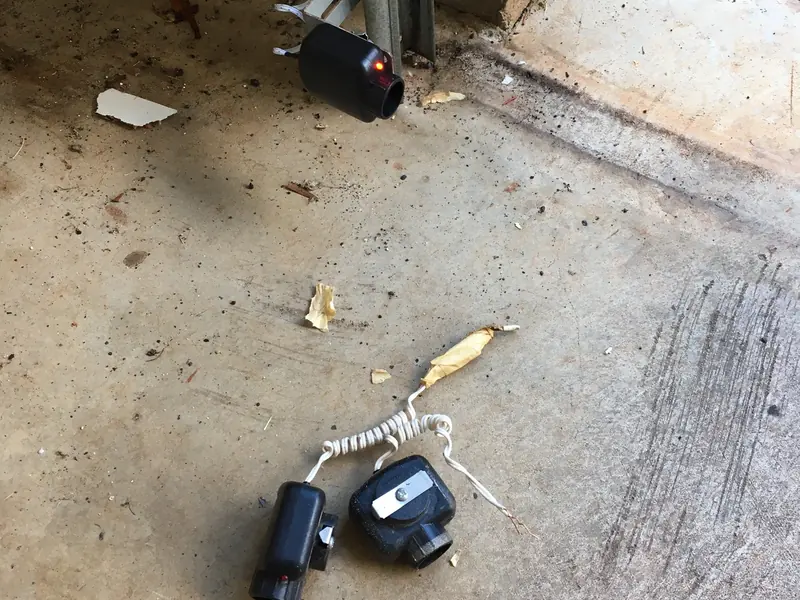 New pair of garage door safety sensors on the floor by the door track