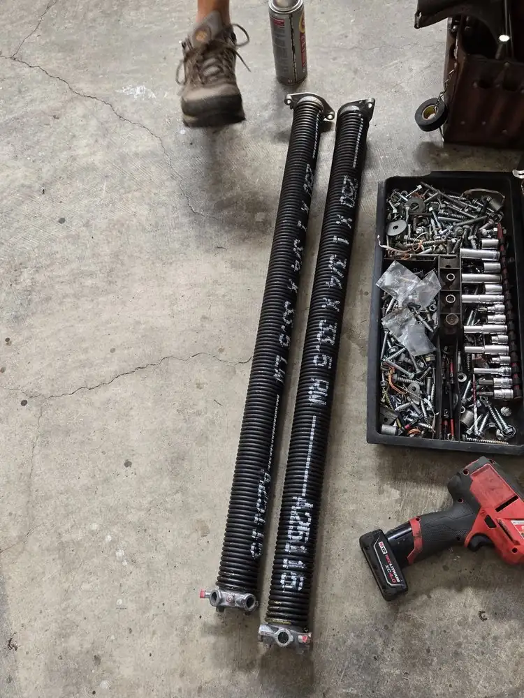 New replacement torsion springs laid out with hardware
