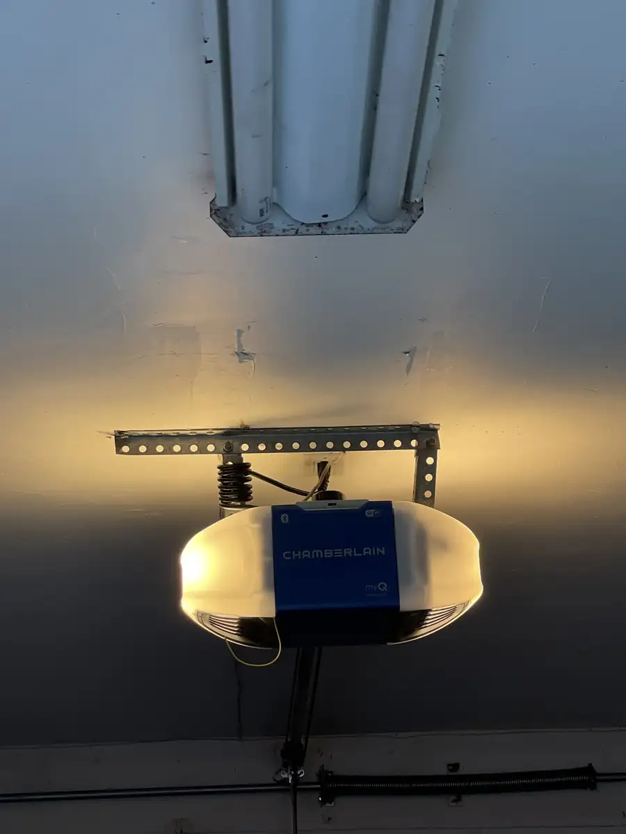 Belt-drive garage door opener mounted on a garage ceiling